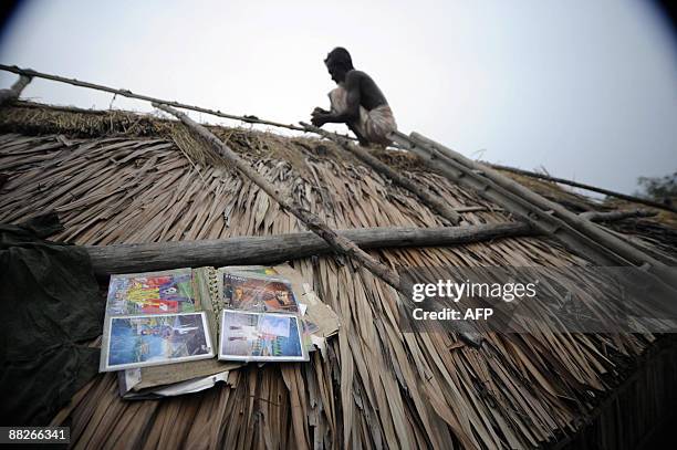 Displaced Bangladeshi villagers dry their family album on the roof of a makeshift shelter by an embankment in Padmapukir on the outskirts of Satkhira...