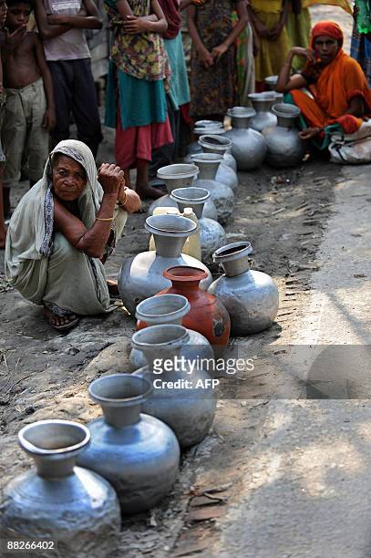 Bangladeshi displaced villagers queue up to collect water in Gabura, on the outskirts of Sathkhira, some 450 kms from Dhaka on June 2, 2009....