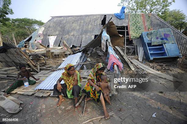 Bangladeshi villagers sit outside their destroyed home at Gabura, on the outskirts of Satkhira, some 450 kms from Dhaka on June 2, 2009. Bangladesh...