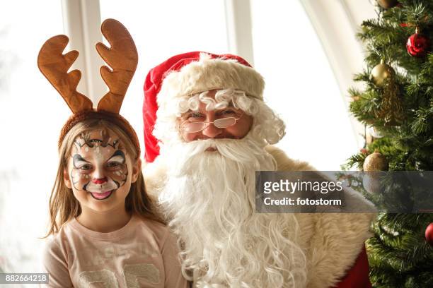 rudolph das rote gerochene ren und santa claus - face painting kids stock-fotos und bilder
