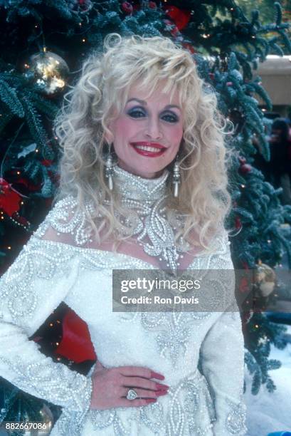 American singer and songwriter Dolly Parton poses for a portrait in front of a Christmas Tree circa December, 1988 in Lake Tahoe, California.