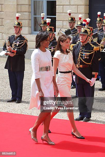 Carla Bruni Sarkozy and Michelle Obama review troops as they arrive at Caen prefecture on June 6, 2009 in Caen, France. Political leaders and...