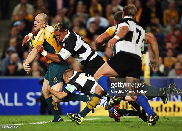 Stirling Mortlock of the Wallabies is tackled by Jerry Collins and Chris Whitaker of the Barbarians during the Nick Shehadie Cup match between the...