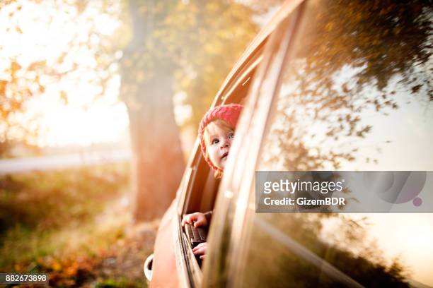 de kleine jongen kijkt uit het raam van de auto - solar flare stockfoto's en -beelden