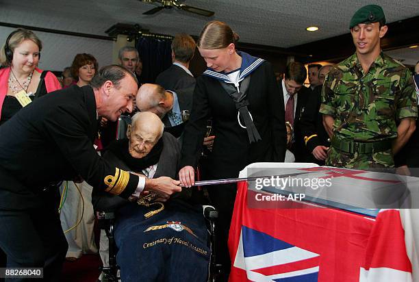Henry Allingham , Britain`s oldest man and oldest surviving First World War veteran cuts the cake during celebrations to mark his 113th birthday at...