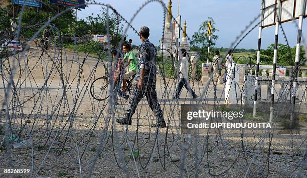 Nepalese policeman stands guard behind barbed wire on the Indo-Nepal border at Kakrvitta some 46 kms from Siliguri on June 6, 2009. After Prachanda's...