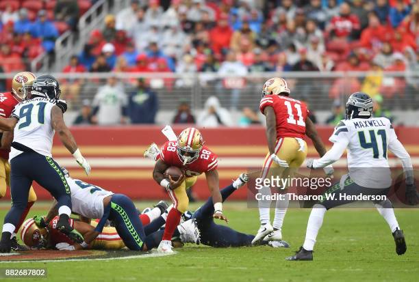 Carlos Hyde of the San Francisco 49ers gets tripped up by Bradley McDougald of the Seattle Seahawks during their NFL football game at Levi's Stadium...