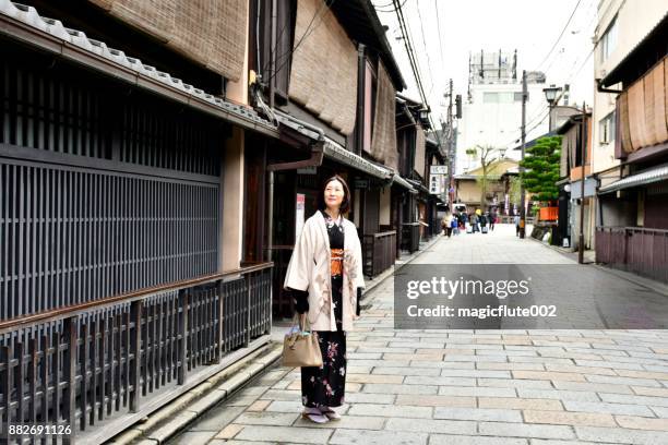 京都の古いセクションで歩いている着物姿の日本女性 - オーバーコート ストックフォトと画像