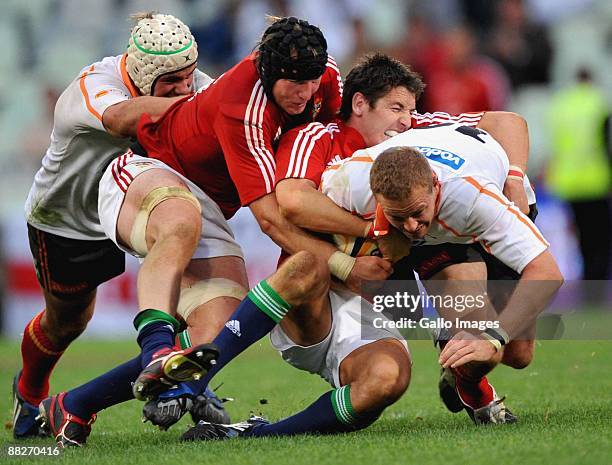 Meyer Bosman of the Cheetahs is stopped by Stephen Ferris and James Hook of the British & Irish Lions during the British and Irish Lions Tour match...