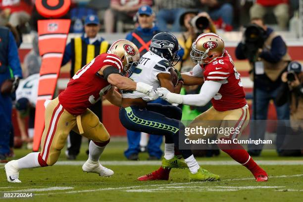 Tyler Lockett of the Seattle Seahawks is tackled by Brock Coyle and Reuben Foster of the San Francisco 49ers at Levi's Stadium on November 26, 2017...