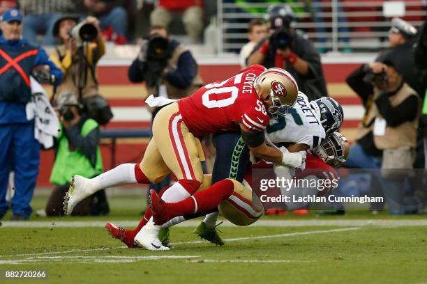 Tyler Lockett of the Seattle Seahawks is tackled by Brock Coyle and Reuben Foster of the San Francisco 49ers at Levi's Stadium on November 26, 2017...