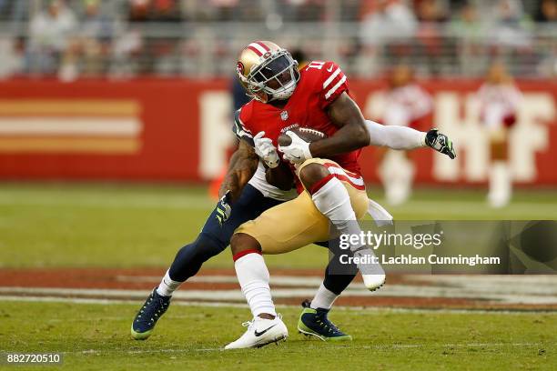 Marquise Goodwin of the San Francisco 49ers is tackled by Earl Thomas of the Seattle Seahawks at Levi's Stadium on November 26, 2017 in Santa Clara,...