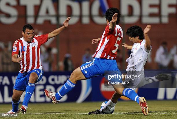 Chilean Matias Fernandez shoots to score despite the effort of Paraguayans Julio Caceres and Julio Manzur during their match for the Fifa World Cup...