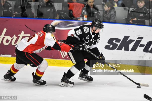 Luke Henman of the Blainville-Boisbriand Armada skates the puck against Gabriel Fortier of the Baie-Comeau Drakkar during the QMJHL game at Centre...