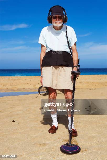 metal detector man on the beach. - schatzoeken stockfoto's en -beelden