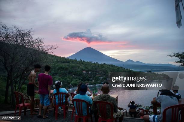 Tourists gather to watch Mount Agung at Amed beach in Karangasem on Indonesia's resort island of Bali on November 30, 2017. Thousands of foreign...