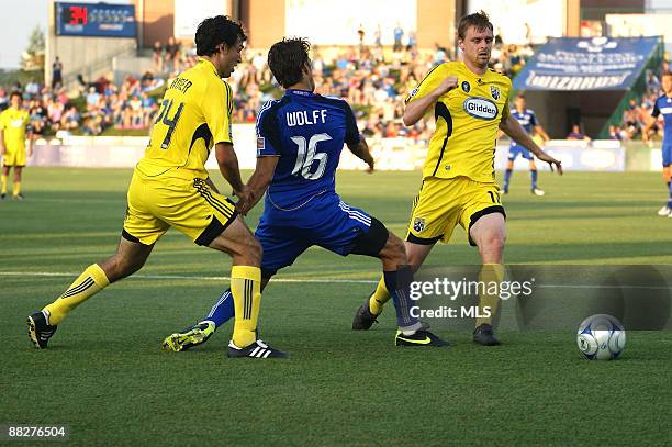 Josh Wolff of the Kansas City Wizards challenges Eddie Gaven of the Columbus Crew while Jed Zayner of the Columbus Crew watches during the game at...