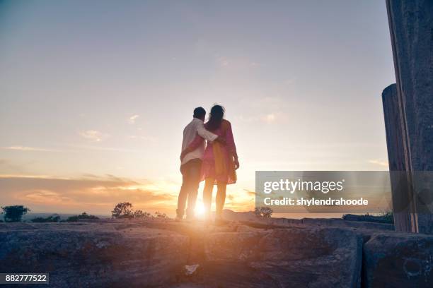 paar knuffelen van achter - picnic rug stockfoto's en -beelden