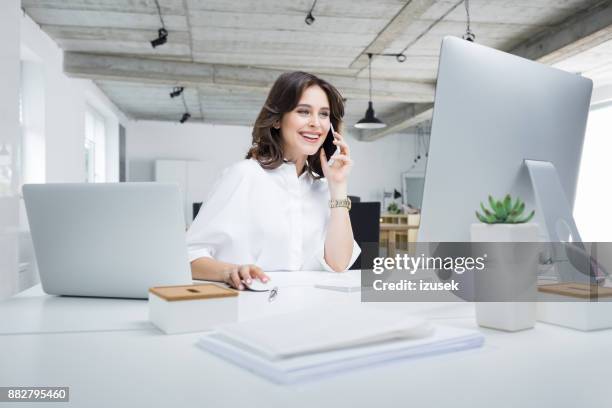 geschäftsfrau arbeiten in modernen arbeitsplatz - business woman on phone stock-fotos und bilder