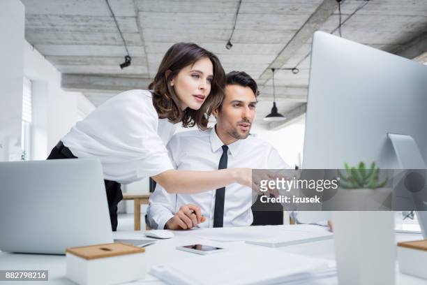 mensen uit het bedrijfsleven werken samen aan computer - business couple showing stockfoto's en -beelden