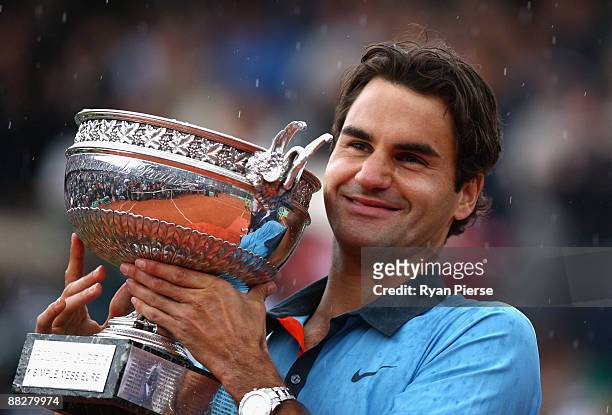 Roger Federer of Switzerland poses with the trophy as he celebrates victory during the Men's Singles Final match against Robin Soderling of Sweden on...