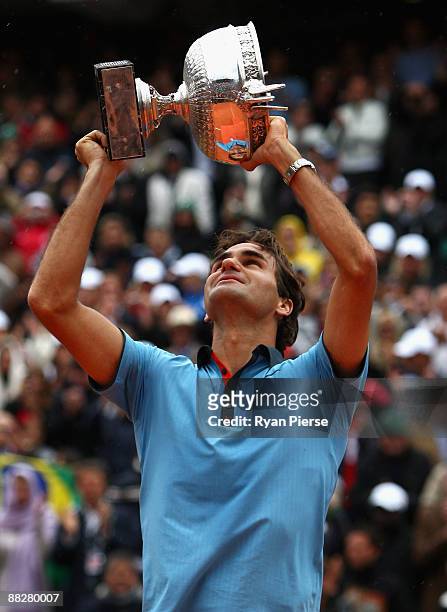 Roger Federer of Switzerland lifts the trophy as he celebrates victory during the Men's Singles Final match against Robin Soderling of Sweden on day...