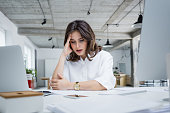 Female entrepreneur with headache sitting at desk