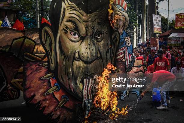 Filipino leftist protesters burn an image of President Rodrigo Duterte on November 30, 2017 in Manila, Philippines. After announcing his withdrawal...
