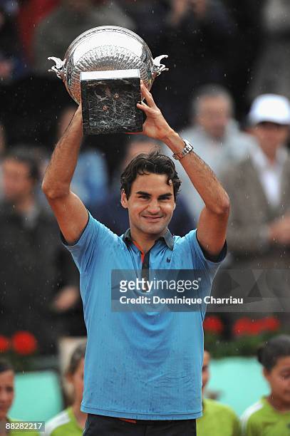 Roger Federer of Switzerland poses with the trophy as he celebrates victory during the Men's Singles Final match against Robin Soderling of Sweden on...