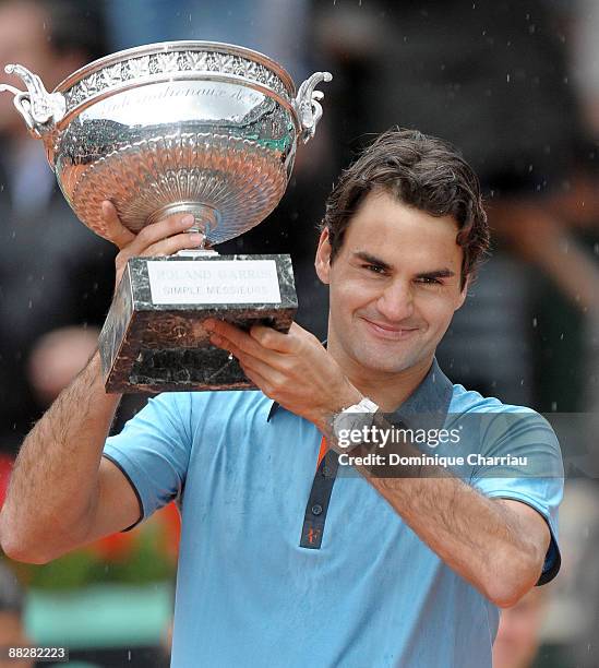 Roger Federer of Switzerland poses with the trophy as he celebrates victory during the Men's Singles Final match against Robin Soderling of Sweden on...