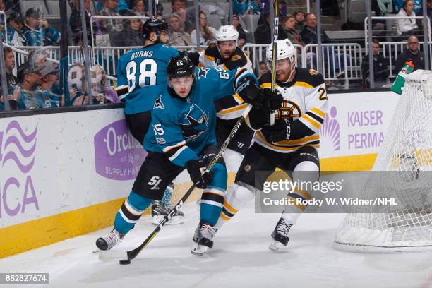 Daniel O'Regan of the San Jose Sharks skates with the puck against Jordan Szwarz of the Boston Bruins at SAP Center on November 18, 2017 in San Jose,...