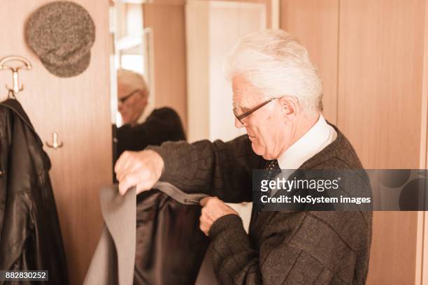 seniors at home. senior man  looking himself at the mirror, getting dresses - one man only photos stock pictures, royalty-free photos & images