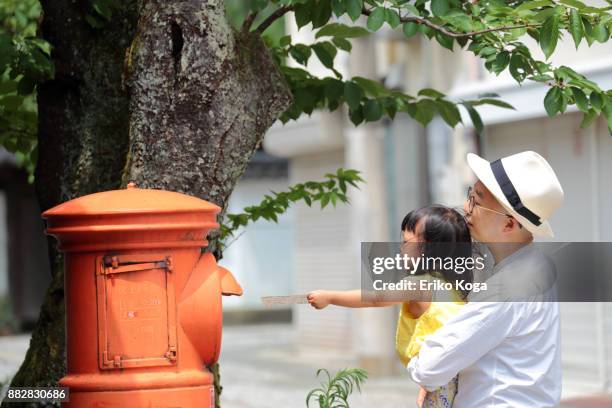 daughter with father posting in mailbox - toyooka stock pictures, royalty-free photos & images