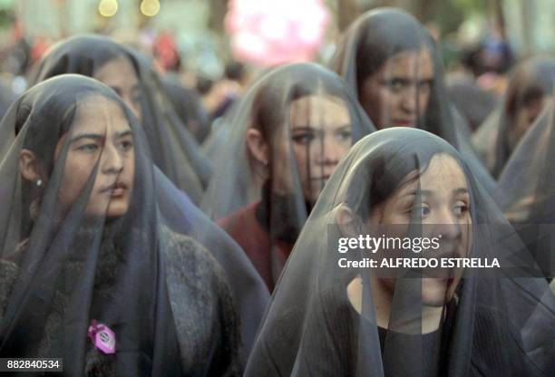 This 25 November 2002 picture shows women, members of social and non-governmental organizations marching with black veils in Mexico City on the "No...