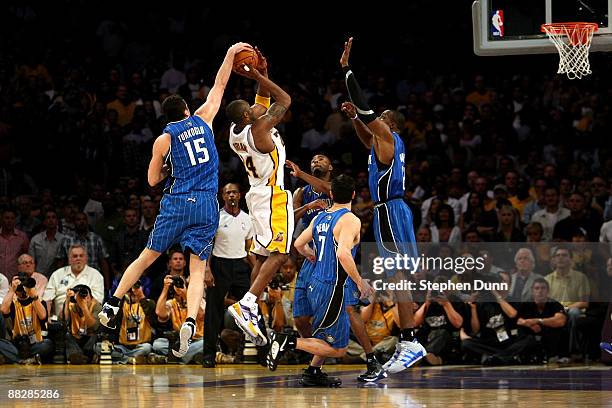 Kobe Bryant of the Los Angeles Lakers goes up for a shot over Hedo Turkoglu, Rashard Lewis, J.J. Redick and Dwight Howard of the Orlando Magic in the...