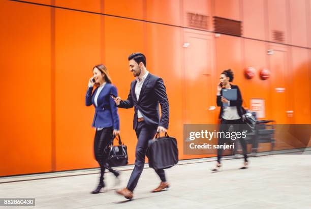 business people walking, blurred motion - businesswoman talking smartphone stock pictures, royalty-free photos & images