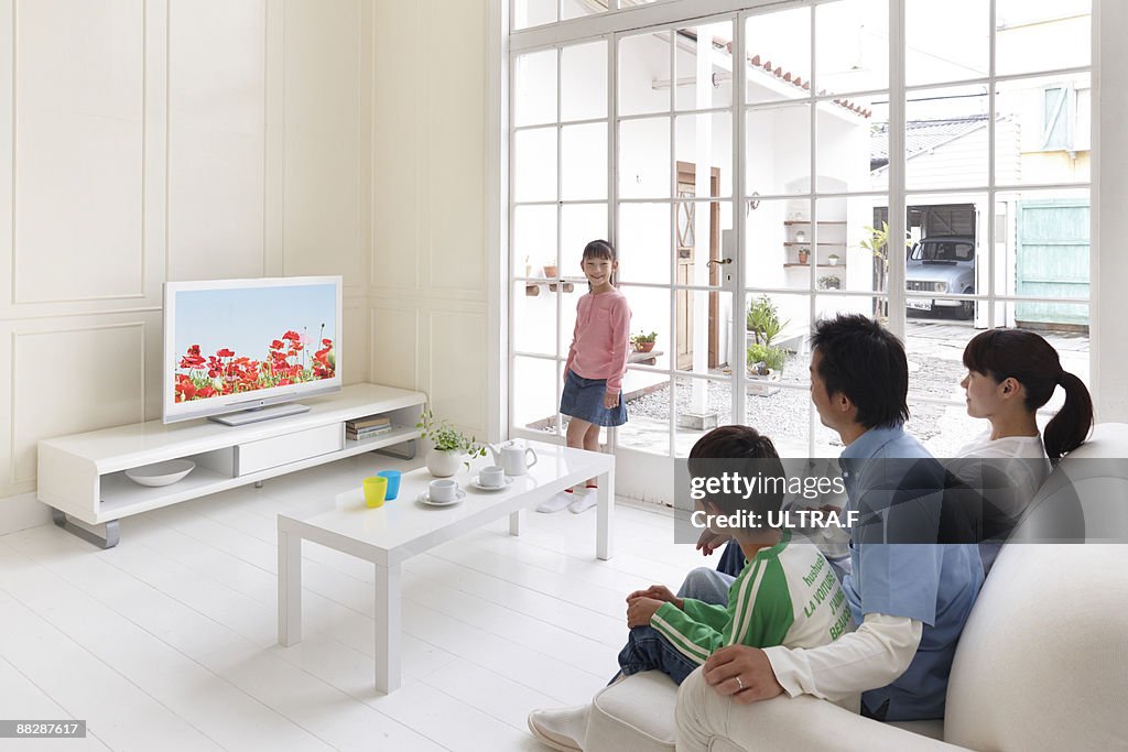 A family watching TV in the living room.