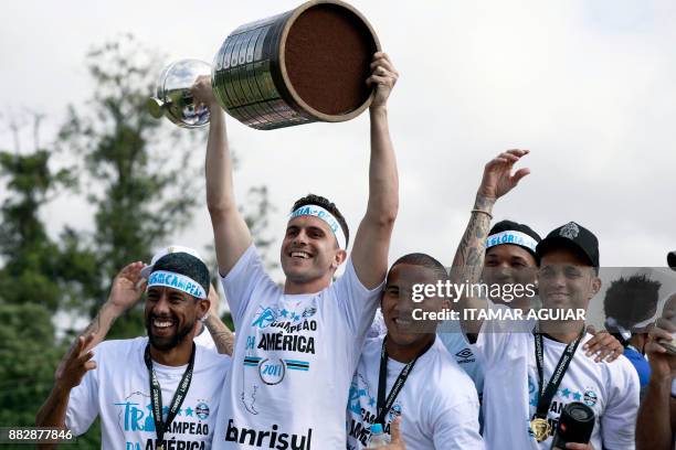 Brazil's Gremio goalkeeper Marcelo Grohe raises the Copa Libertadores 2017 trophy next to his teammates, as he celebrates their victory in Porto...