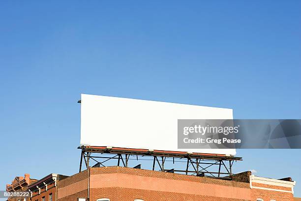 blank billboard sign on building rooftop - empty city foto e immagini stock