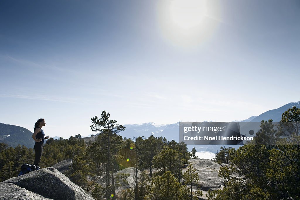 Woman on top of mountain, looking at view