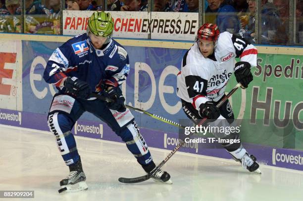Oscar Eklund of Iserlohn Roosters and Justin Shugg of Koeln battle for the ball during the DEL match between Iserlohn Roosters and Kölner Haie on...