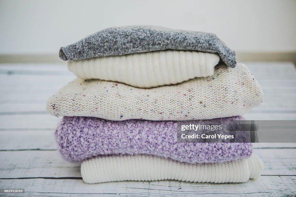 Variety of sweaters piled up.