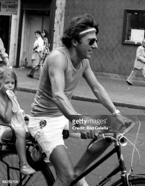 Actor Dustin Hoffman and daughter being photographed riding his bike on April 18, 1976 on West 44th Street in New York City, New York.