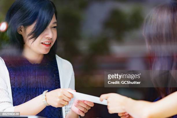 freelance japanese girl getting paid for her work - receiving paycheck stock pictures, royalty-free photos & images