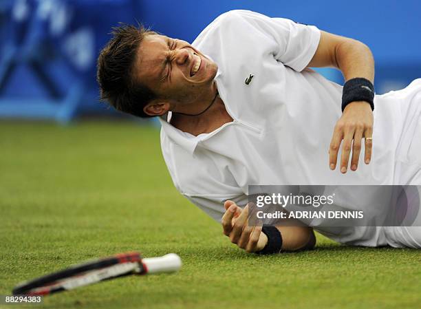 Nicolas Mahut of France falls to the ground after losing his footing during the game against Janko Tipsarevic of Serbia at the first round match at...