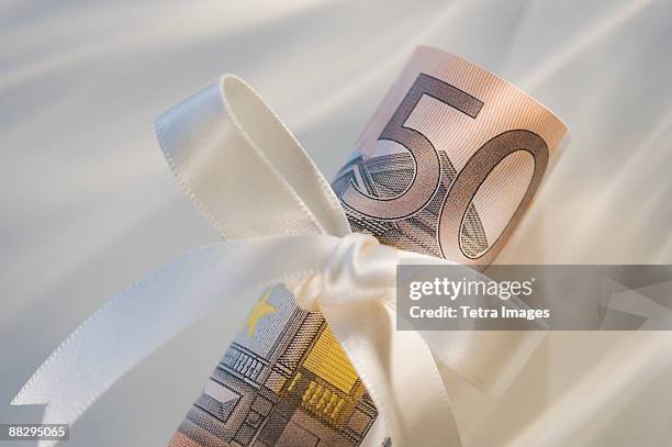 50 euro note wrapped in ribbon - billet de 50 euros photos et images de collection