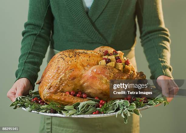 man holding thanksgiving turkey on decorated platter - turkey imagens e fotografias de stock