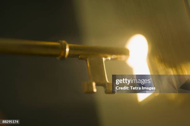 close up of keyhole and key - sleutel stockfoto's en -beelden