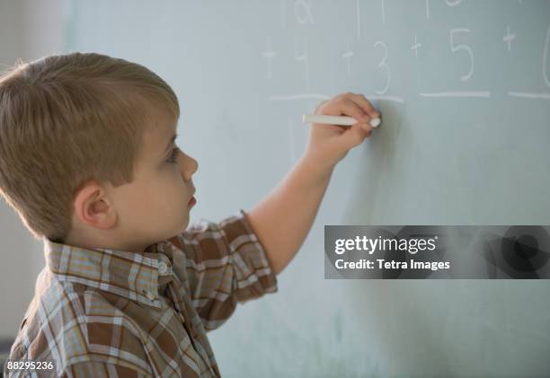 Kid Writing Down Math Math Young Boy Writes Math Equations On Chalkboard Photos and Premium High ...