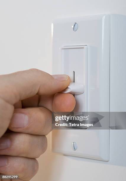 man adjusting light dimmer - dimmer switch stock pictures, royalty-free photos & images
